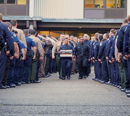 police officers walking down aisle between other police officers